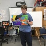 Student displaying his artwork