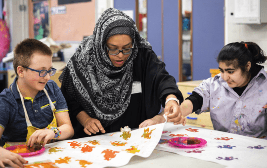 Two students and a Teaching Assistant in art class Two students and a Teaching Assistant in art class